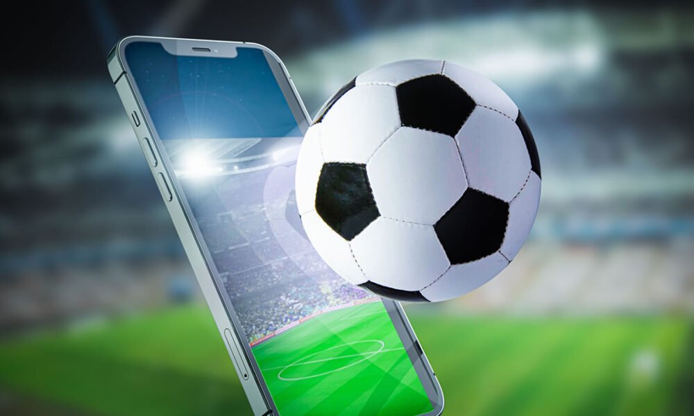 Celular, campo de futebol e bola