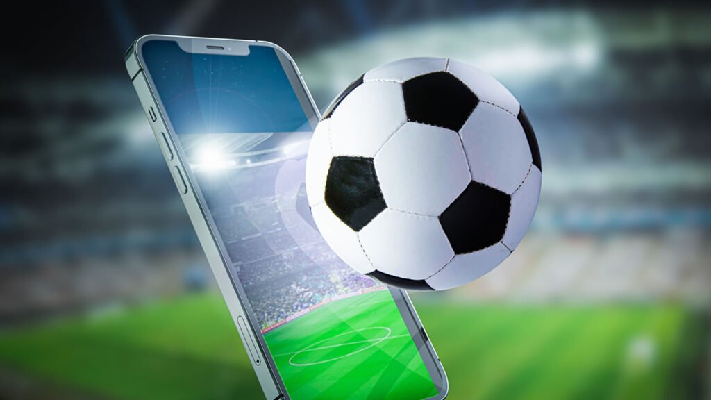 Celular, campo de futebol e bola