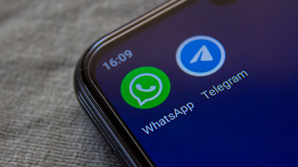 Tela de um celular com fundo preto exibindo icones do WhatsApp e do Telegram