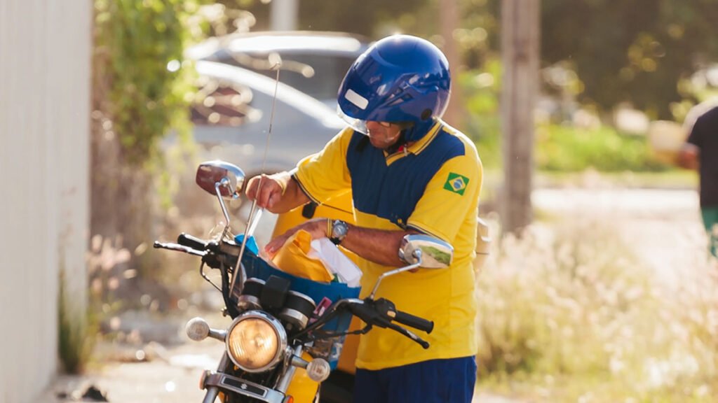 Carteiro de moto fazendo entregas