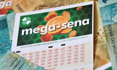 Bilhete Mega-Sena ao fundo notas de reais