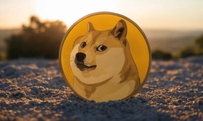 Moeda Dogecoin enterrada na areia no por do sol