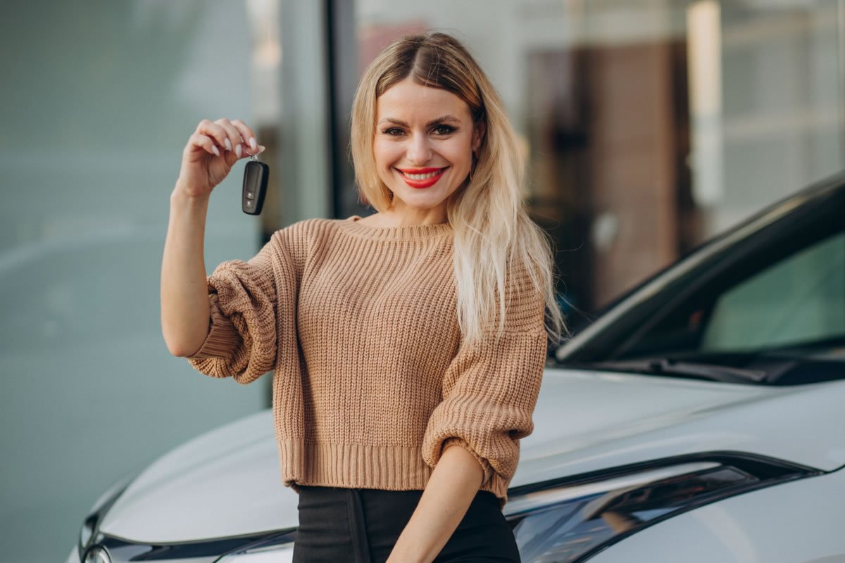 IPVA Mulher na frente do carro segurando a chave