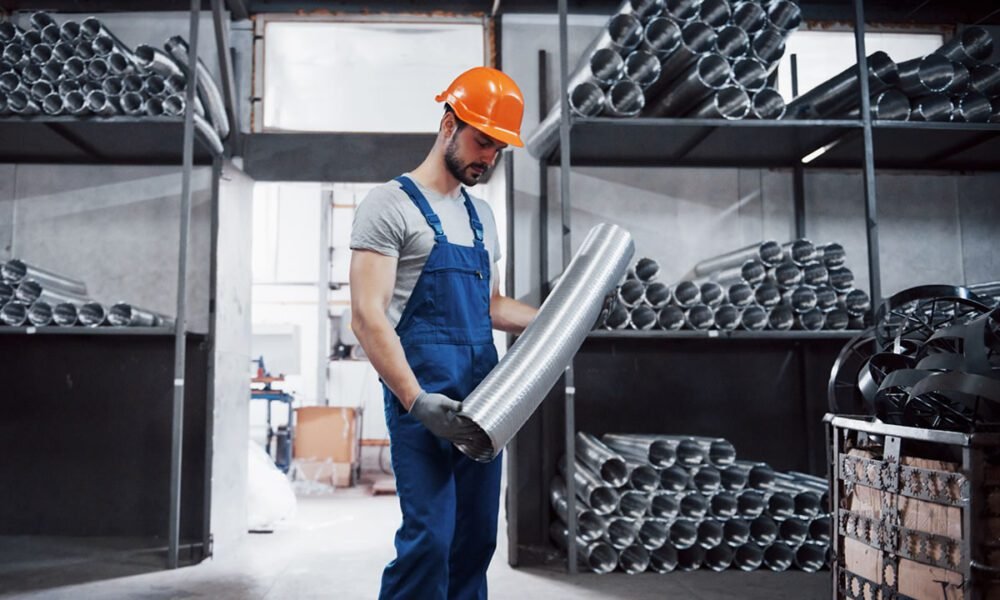 retrato-de-um-jovem-trabalhador-em-um-capacete-em-uma-grande-usina-de-metais